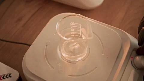 Perfumer Mixing Essential Oils in Beaker on Magnetic Stirrer Stock-Footage 337111510