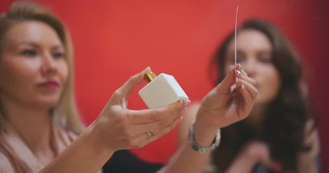 Perfumer testing new fragrance and giving female customer smelling it Stock Footage 105035054