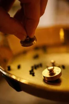 A perfumer using small weights at perfumery Photos