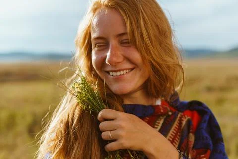Perky laughter on the face of a red-haired girl with freckles who stands in the Stock Photos
