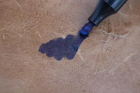 Permanent blue marker scribbling on brown leather Stock Photos