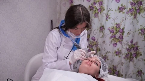 Permanent eyebrow makeup. A specialist makes a form using a typewriter. 4K Slow Vídeo Stock 106892762