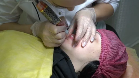 Permanent lip makeup. Microblading procedure. The beautician increases the lips  스톡 동영상 99692504