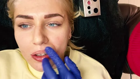 Permanent lip makeup. Top view of a young blue-eyed woman. Master applies Stock-Footage 161967000