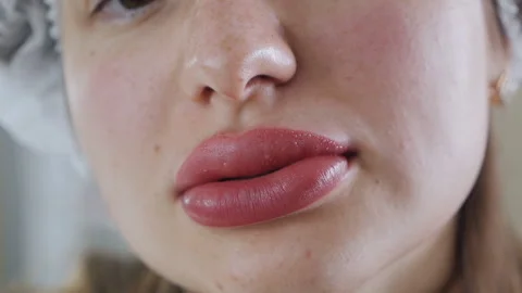 Permanent lip makeup.Close-up of huge, swollen lips after permanent makeup Stock Footage 166175786