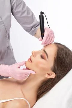 Permanent make-up for eyebrows and lips of beautiful woman in beauty salon... Stock Photos