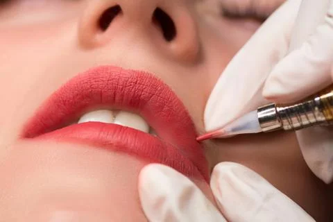 Permanent make up procedure, applying on young girl. Lip makeup in tattoo sal Stock Photos