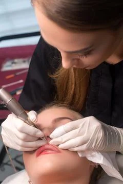 Permanent make up procedure. Lip makeup in tattoo salon. Stock Photos