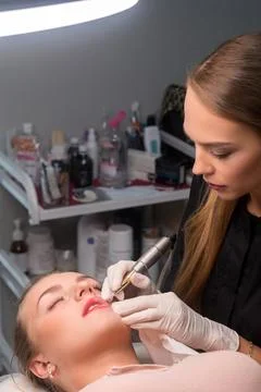 Permanent make up procedure. Lip makeup in tattoo salon. Stock Photos