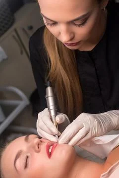 Permanent make up procedure. Lip makeup in tattoo salon. Stock Photos