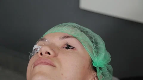 A permanent makeup artist gets a tattoo on a woman's upper eyelids. 库存影片 137545973