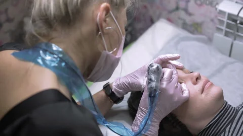Permanent makeup, eyebrow tattooing. The master makes permanent makeup using Stock Footage 200544284