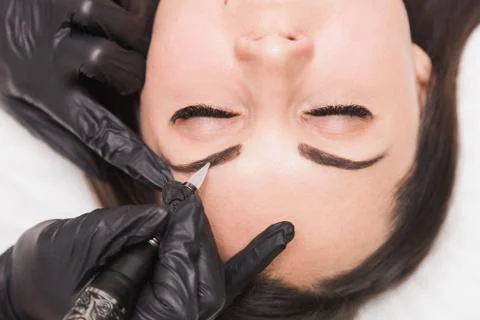 Permanent makeup for eyebrows of beautiful young woman in beauty salon Foto stock