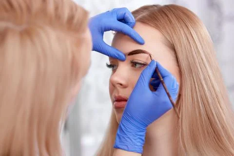 Permanent makeup of eyebrows for blonde woman Stock Photos