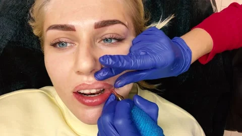 Permanent makeup lips procedure applying pigment makeup on lips with a tattoo 스톡 동영상 162192192