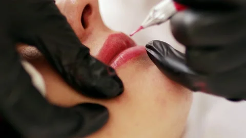 Permanent makeup lips procedure applying rose pigment Stock Footage 220679823