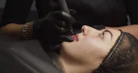 Permanent makeup. The master injects a stable pigment of lips with a needle Stock Footage 167651373
