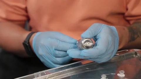 Permanent makeup master prepares a device for tattooing. 库存影片 137537296