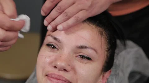 Permanent makeup master wipes the client's face after the procedure. Stock Footage 137549570