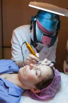 Permanent makeup. Permanent tattooing of eyebrows. Cosmetologist applying per Stock Photos
