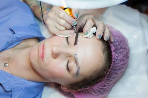 Permanent makeup. Permanent tattooing of eyebrows. Cosmetologist applying per Stock Photos