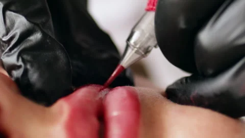 Permanent makeup procedure applying pink color pigment using tattoo machine Stock Footage 255410532