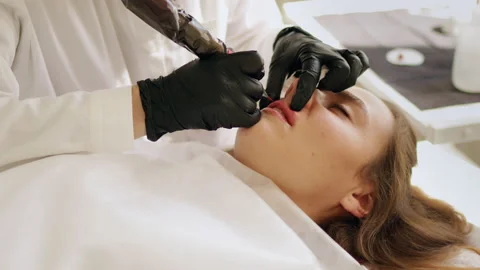 Permanent makeup procedure applying rose red pigment Stock Footage 220679814