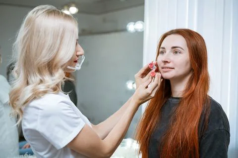 Permanent makeup teacher demonstrates tutorial model. Very handsome lip Foto stock