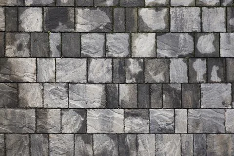 Perpendicular view of a pavement of rectangular stone tiles of various sizes Stock Photos