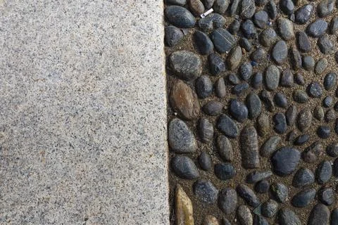 Perpendicular view of a pavement of river pebbles and stone slabs Stock Photos