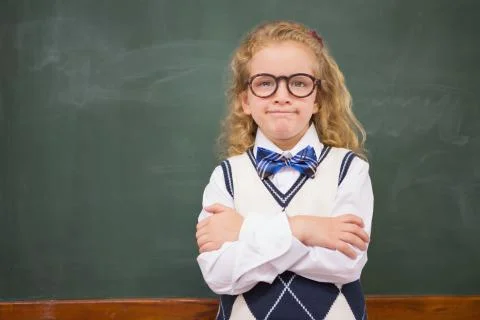 Perplex pupil looking at camera with arms crossed Stock Photos