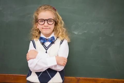 Perplex pupil looking at camera with arms crossed Stock Photos