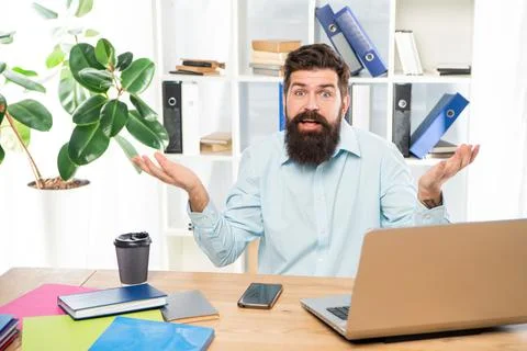 Perplexed guy making helpless gesture working at office desk, perplexity Stock Photos