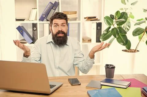 Perplexed guy making helpless gesture working at office desk, perplexity Stock Photos