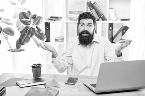 Perplexed guy making helpless gesture working at office desk, perplexity Stock Photos