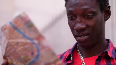 Perplexed young african who does not yet know the language well consults the map Stock Footage 240392557