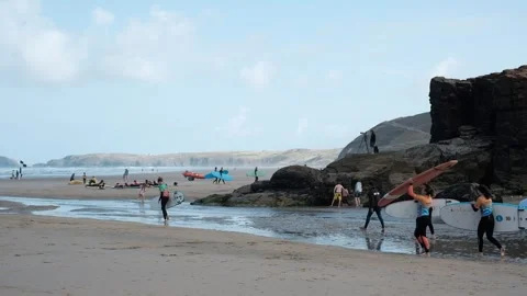 Perranporth, Cornwall, UK, 2 Sept 2024 - Surfers walking Down Beach to the sea Stock Footage 283457813