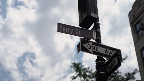The Perry Street Intersection Sign in a busy Urban Environment highlights local Stock Footage 314575357