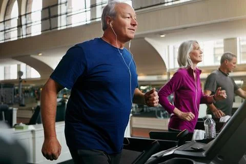 Perseverance pays off. a group of mature people exercising on treadmills at the Stock Photos