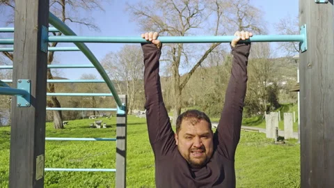 Perseverance in Practice: Man's Attempt at Pull-Ups in the Park Stock Footage 265003931