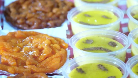 Persian saffron pudding with smiling faces and golden zolbia dessert tilt up Stock Footage 332623413