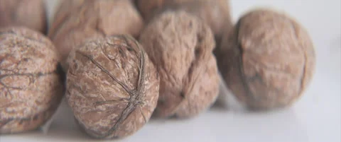Persian walnuts on white background anamorphic 4K sliding video Stock Footage 320228223