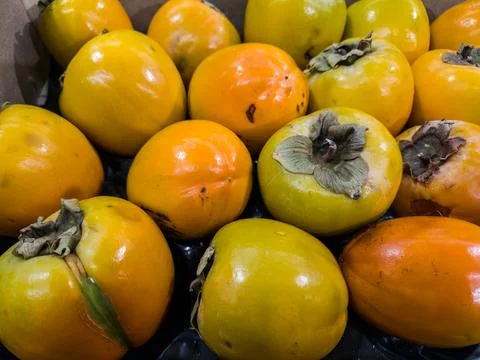 Persimmon background. Persimmon in the store on the counter. Persimmon near Stock Photos