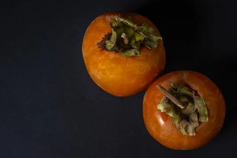 Persimmon on a black background. Stock Photos
