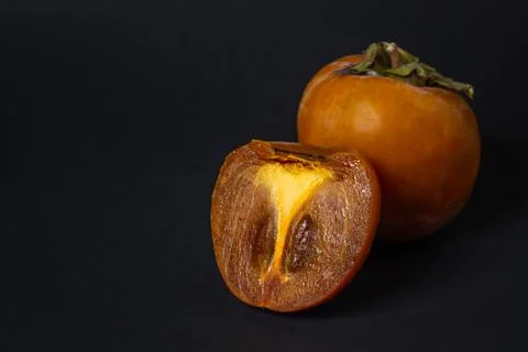 Persimmon on a black background. Stock Photos