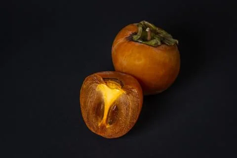 Persimmon on a black background. Stock Photos