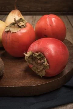 Persimmon fruit on rustic table in vintage style Stock Photos