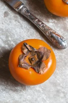 Persimmon fruit on slate background top view. Stock Photos