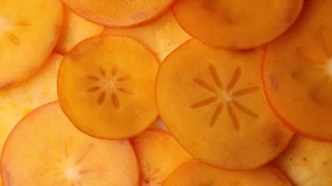 Persimmon slices rotating in circle. Close-up of bright orange dried fruit .. Stock Footage 318903222