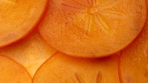 Persimmon slices rotating in circle. Close-up of bright orange dried fruit .. Stock Footage 318903473